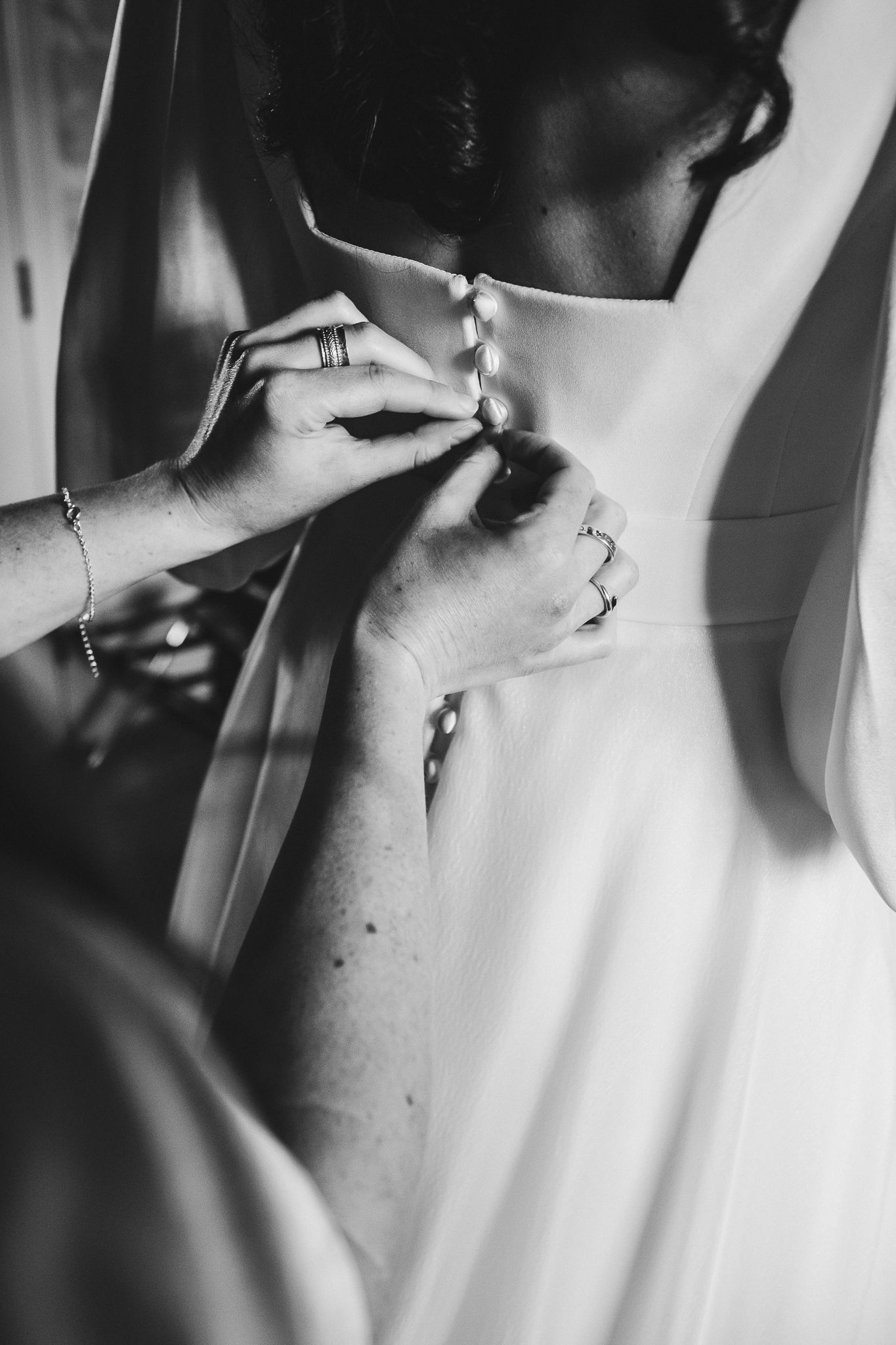 Close-up detail shot of a white wedding dress in black and white.