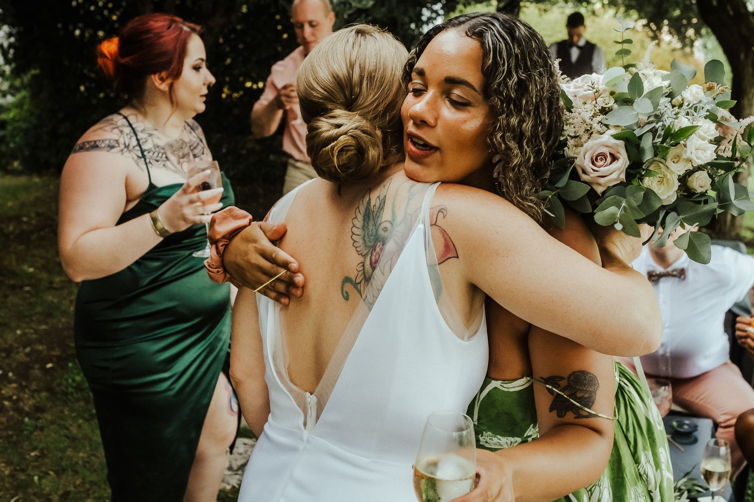 Wedding guests sharing drinks and laughter during an outdoor celebration.