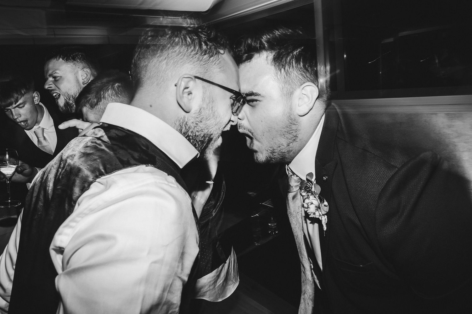 Black and white photograph of two wedding guests sharing an intense moment on the dance floor.