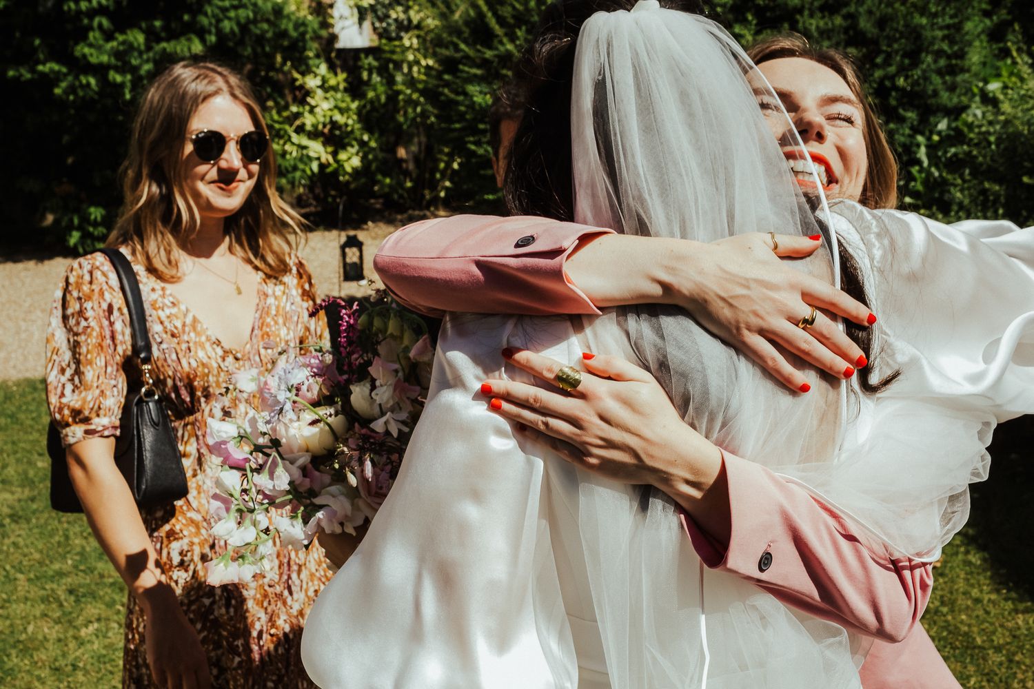 Joyful guests embracing and celebrating at an outdoor wedding.