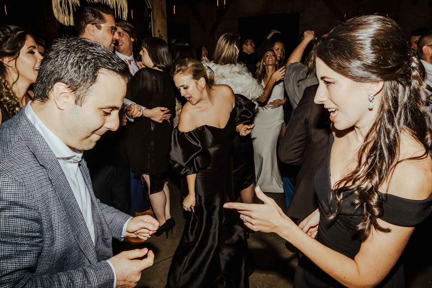 People enjoying themselves on a lively dance floor at an evening celebration.