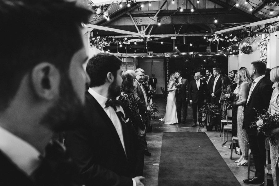 Indoor wedding reception venue with dramatic lighting and guests dancing.