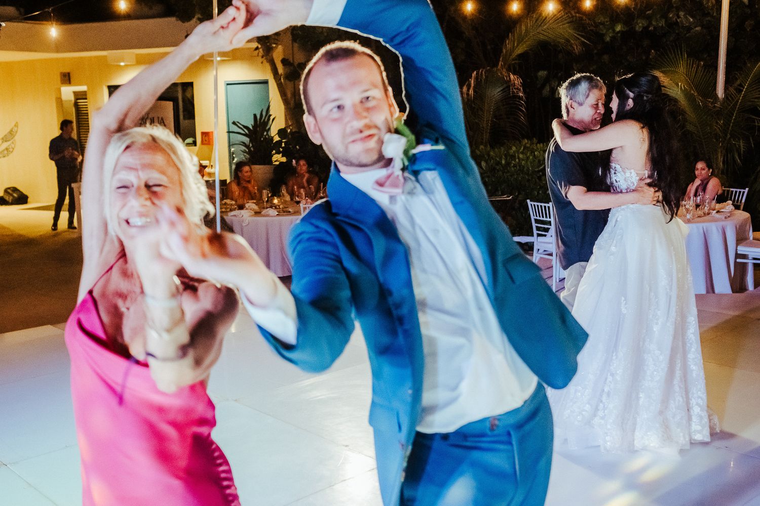 Lively wedding reception dance floor with guests in formal attire.