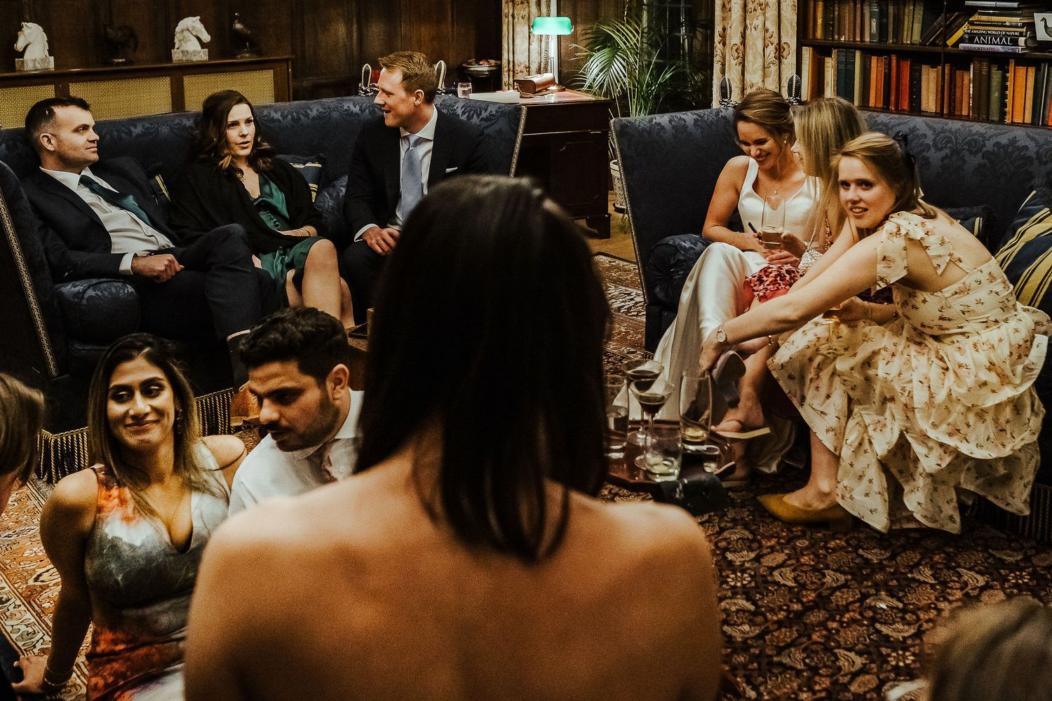 Guests socializing in a cozy library setting during an elegant event.