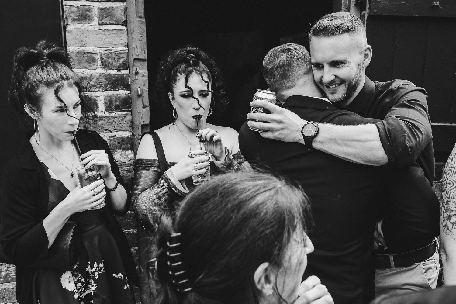 Black and white photo of guests checking their phones during a celebration.