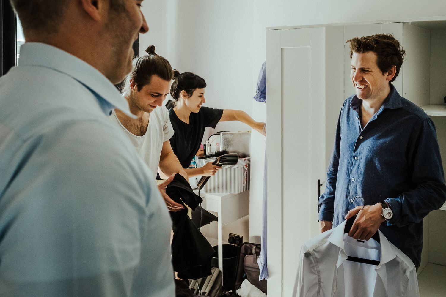 People mingling and socializing in an indoor space with white walls.