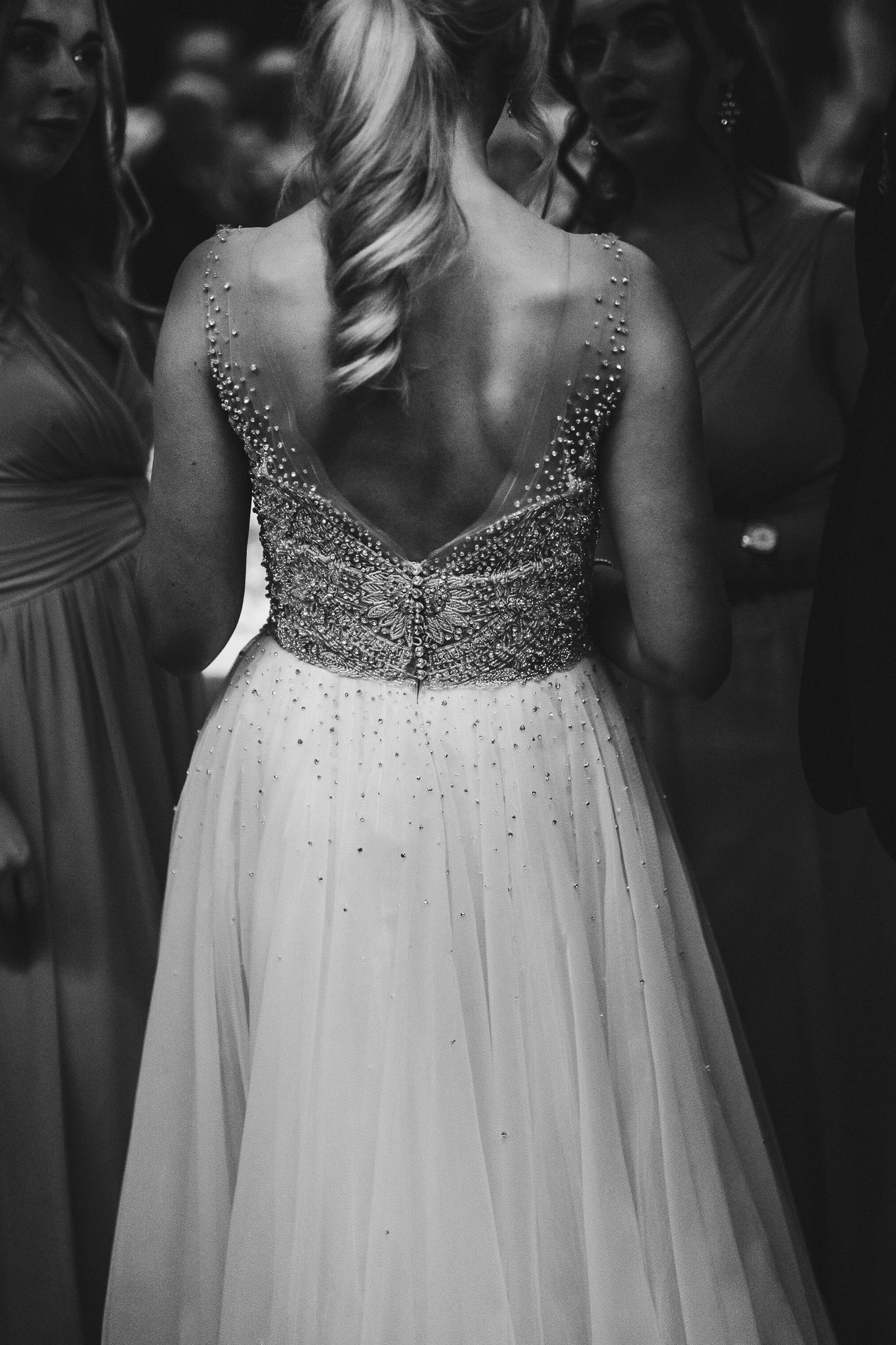 Back view of a sparkling beaded wedding dress bodice with flowing tulle skirt.
