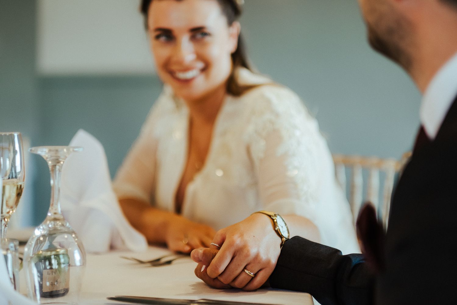 Intimate wedding reception moment captured during quiet conversation at dining table.