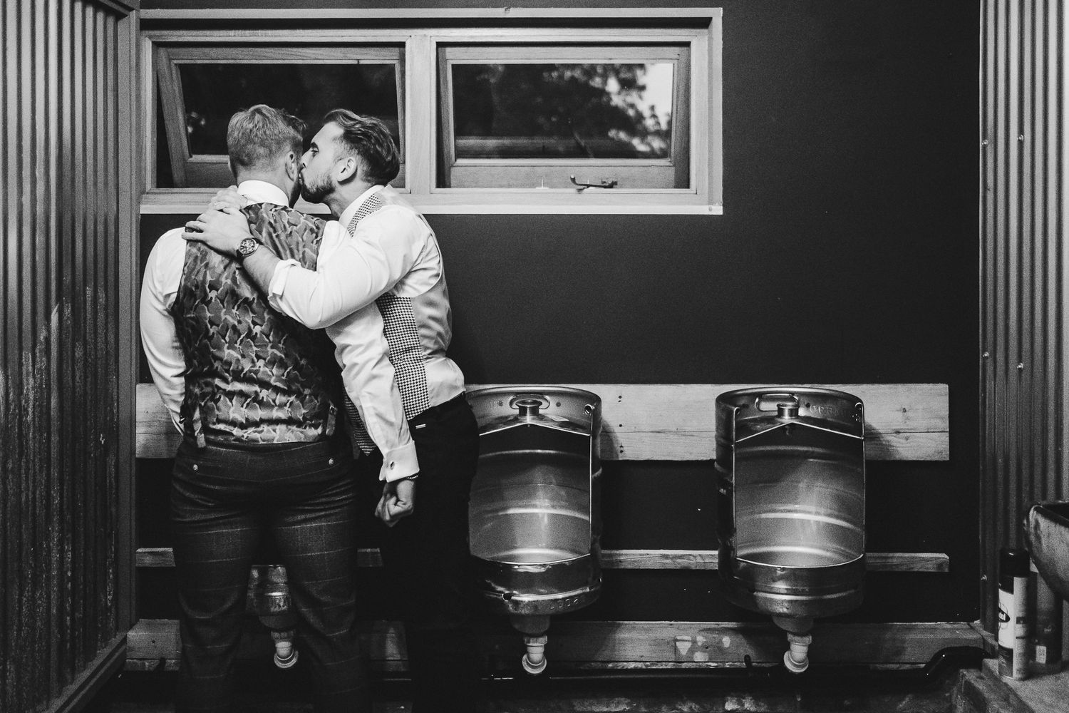 Wedding reception guests dancing and celebrating in an intimate bar setting with vintage decor.