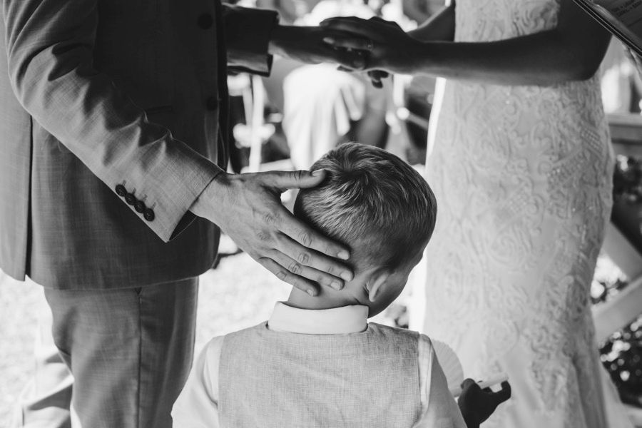 A tender moment captured in black and white as a hand is placed on a young child's head.