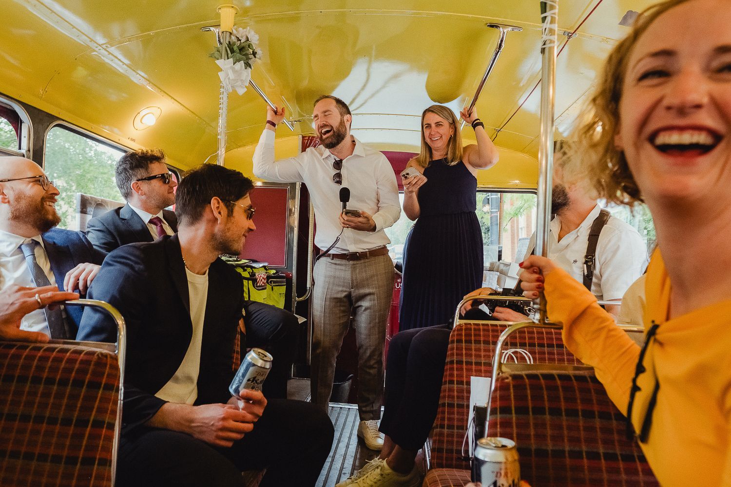People gathered under a yellow tent for a festive outdoor event with drinks and laughter.