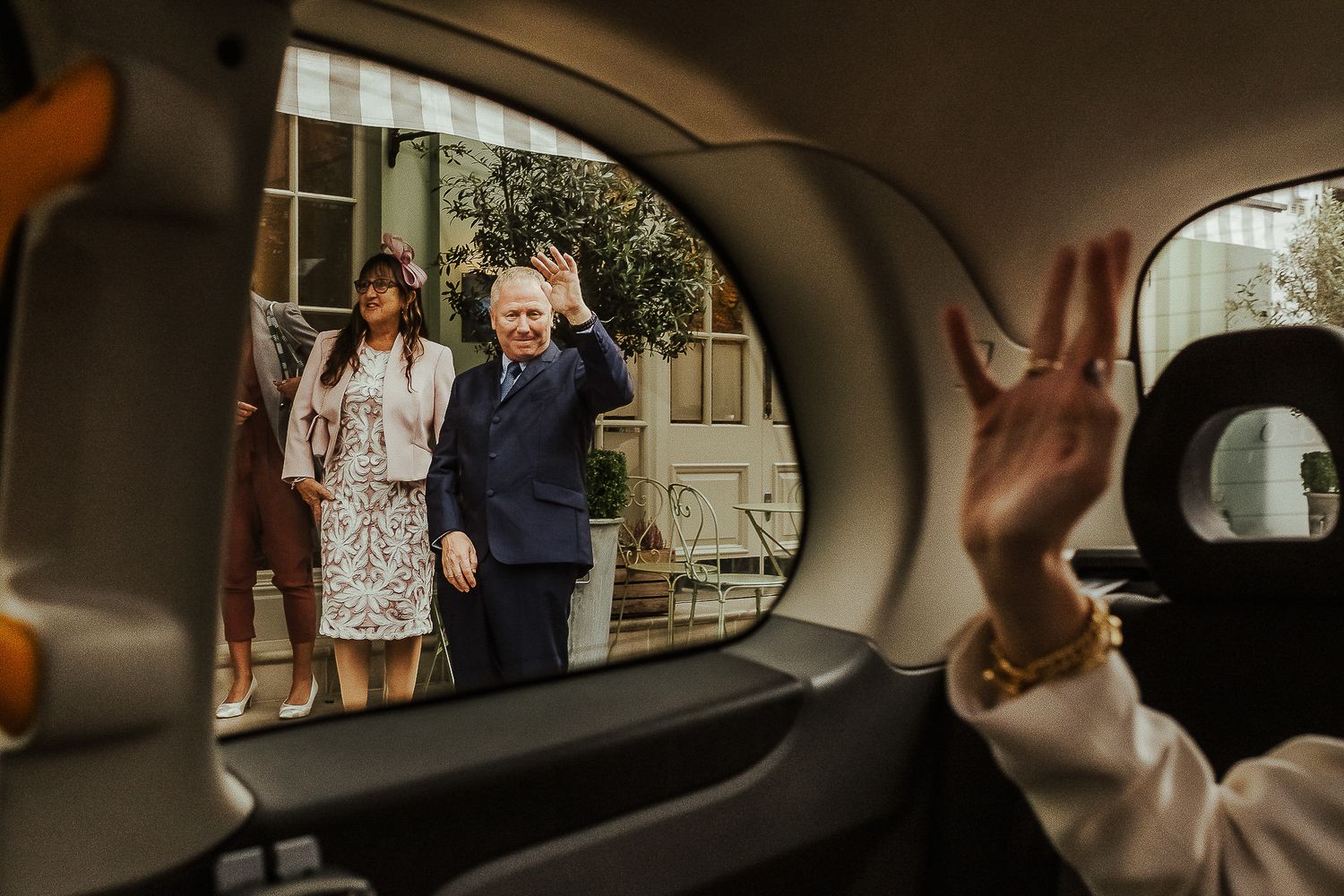 View through a car window of people waiting outside on a cloudy day.