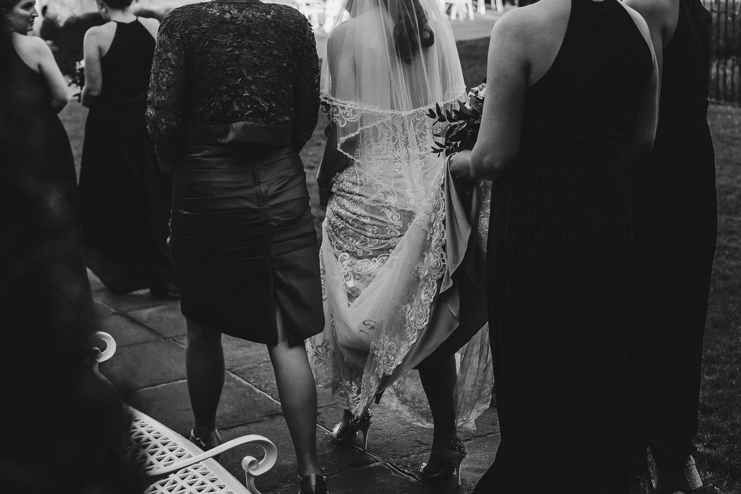Black and white detail shot of elegant lace wedding dress at reception.