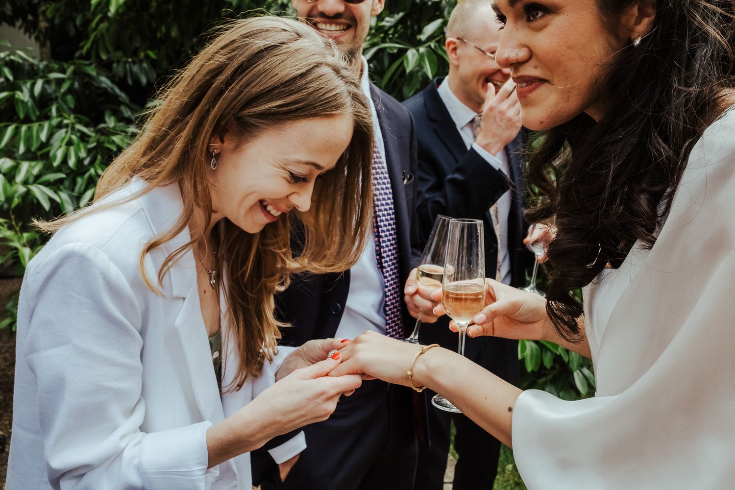 Wedding guests sharing intimate conversations during outdoor reception.