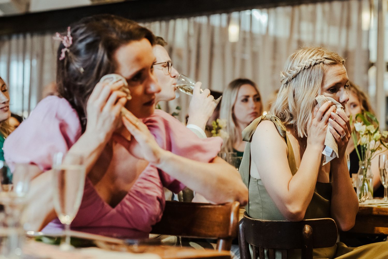 Emotional wedding guests reacting during reception speeches and toasts.
