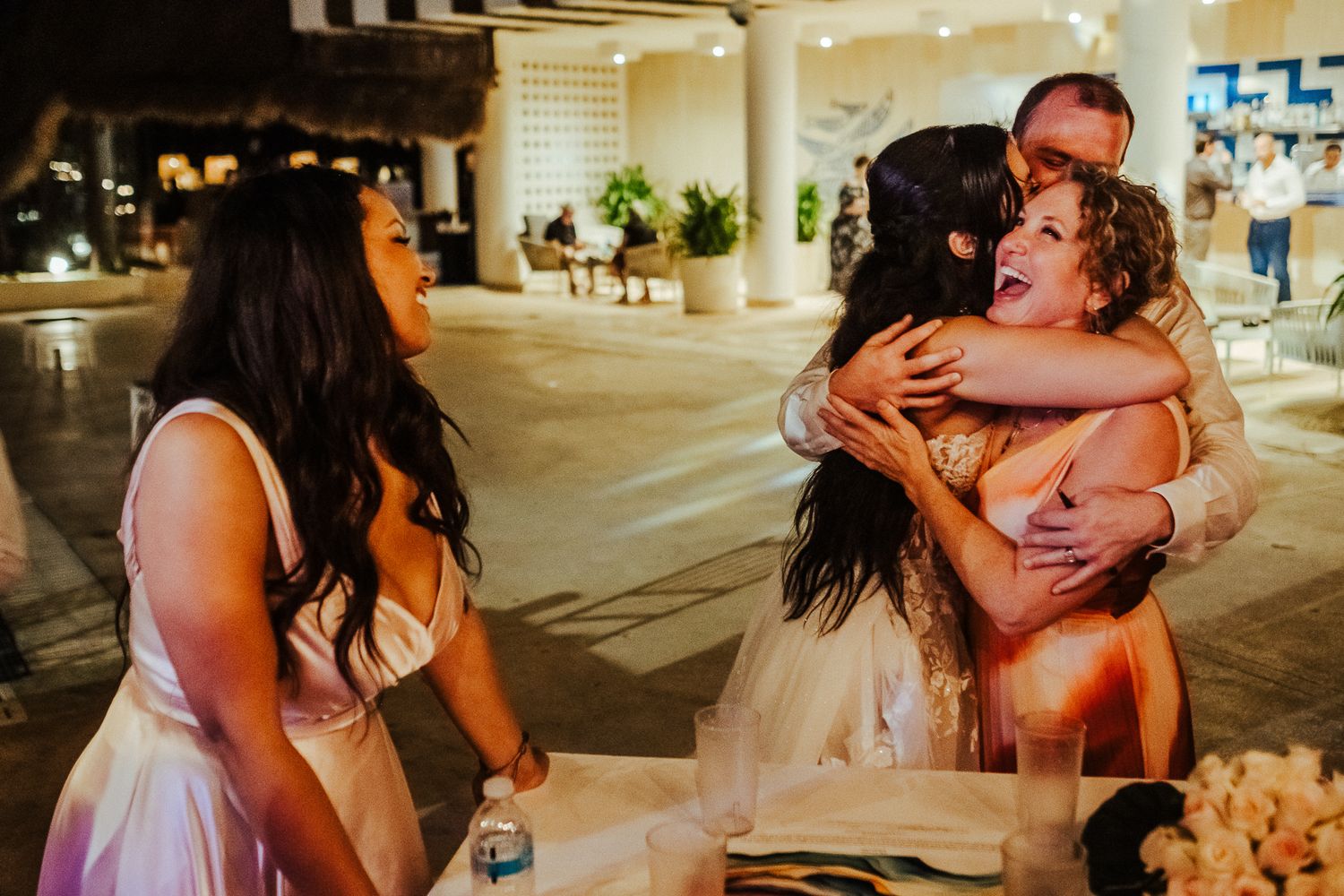 Guests sharing emotional embraces during heartfelt wedding reception moments.