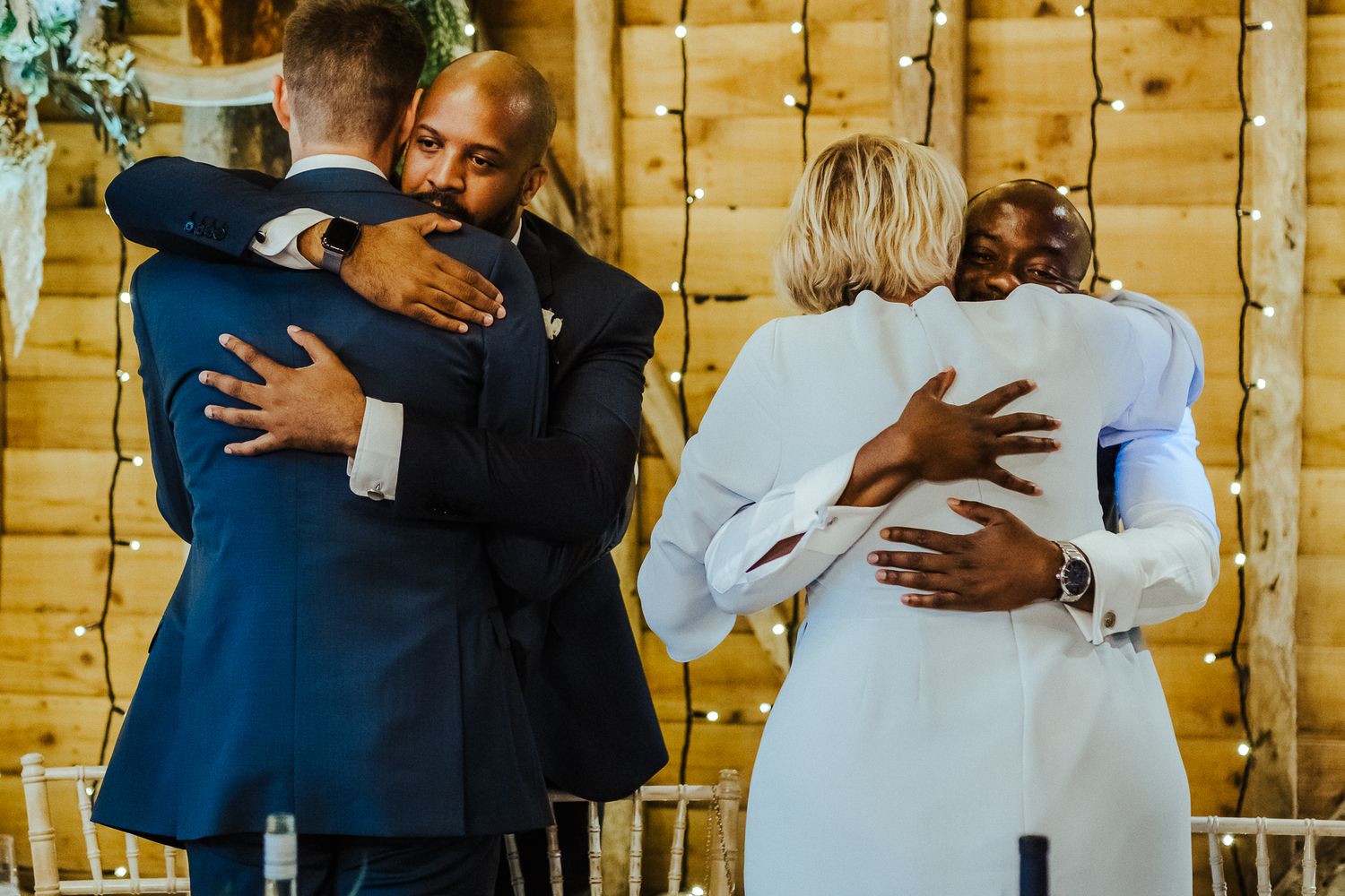Wedding guests exchanging warm embraces during reception celebrations.