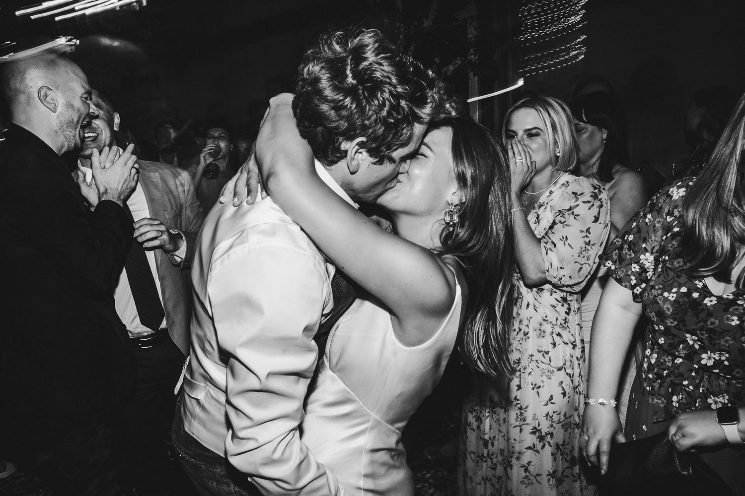 Black and white photo of a romantic dance moment at a dimly lit wedding reception.