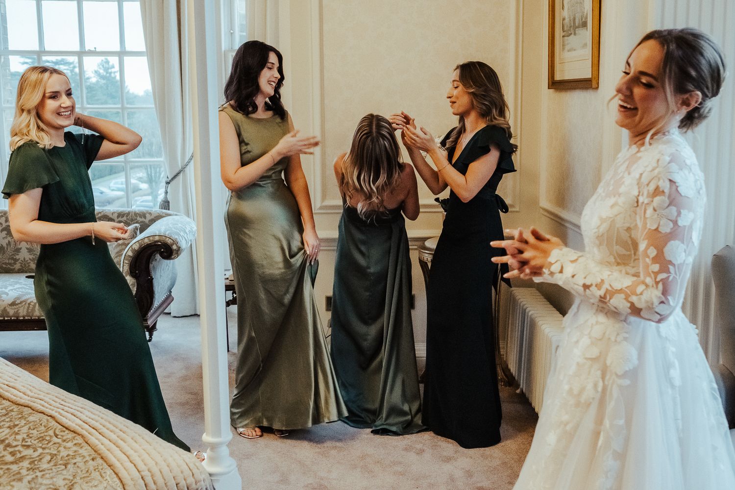 Wedding preparations scene with attendants in dark dresses against floral wallpapered walls.