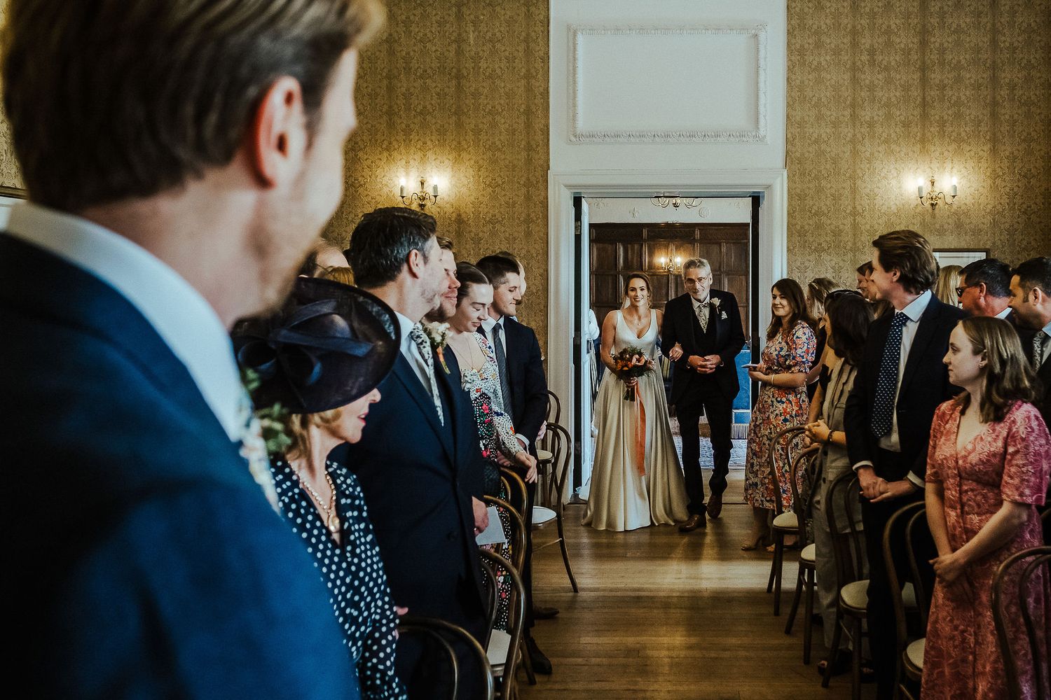 Wedding ceremony in progress with guests watching in elegant venue.