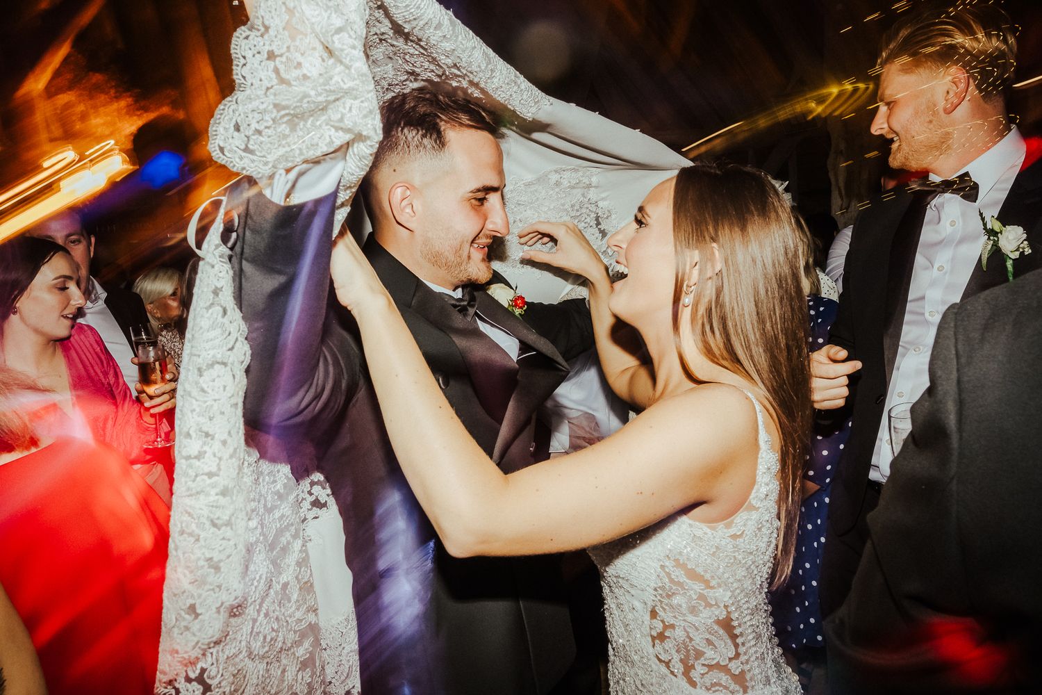 Energetic dance floor moments captured during evening wedding reception celebrations.