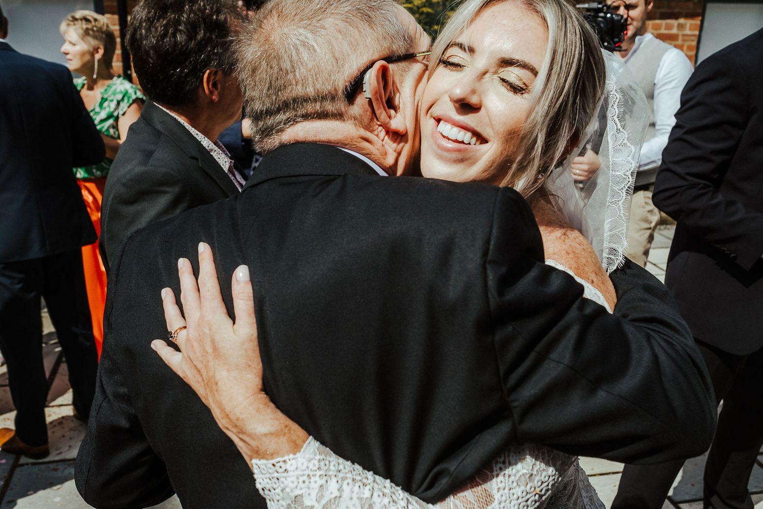 An emotional embrace captured during a wedding celebration outdoors.