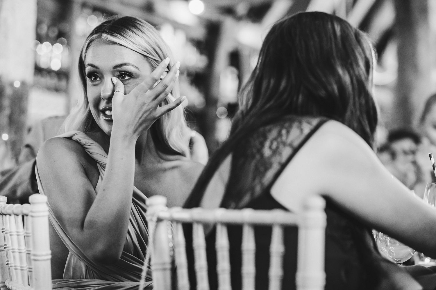 An emotional black and white moment captured during a wedding reception.