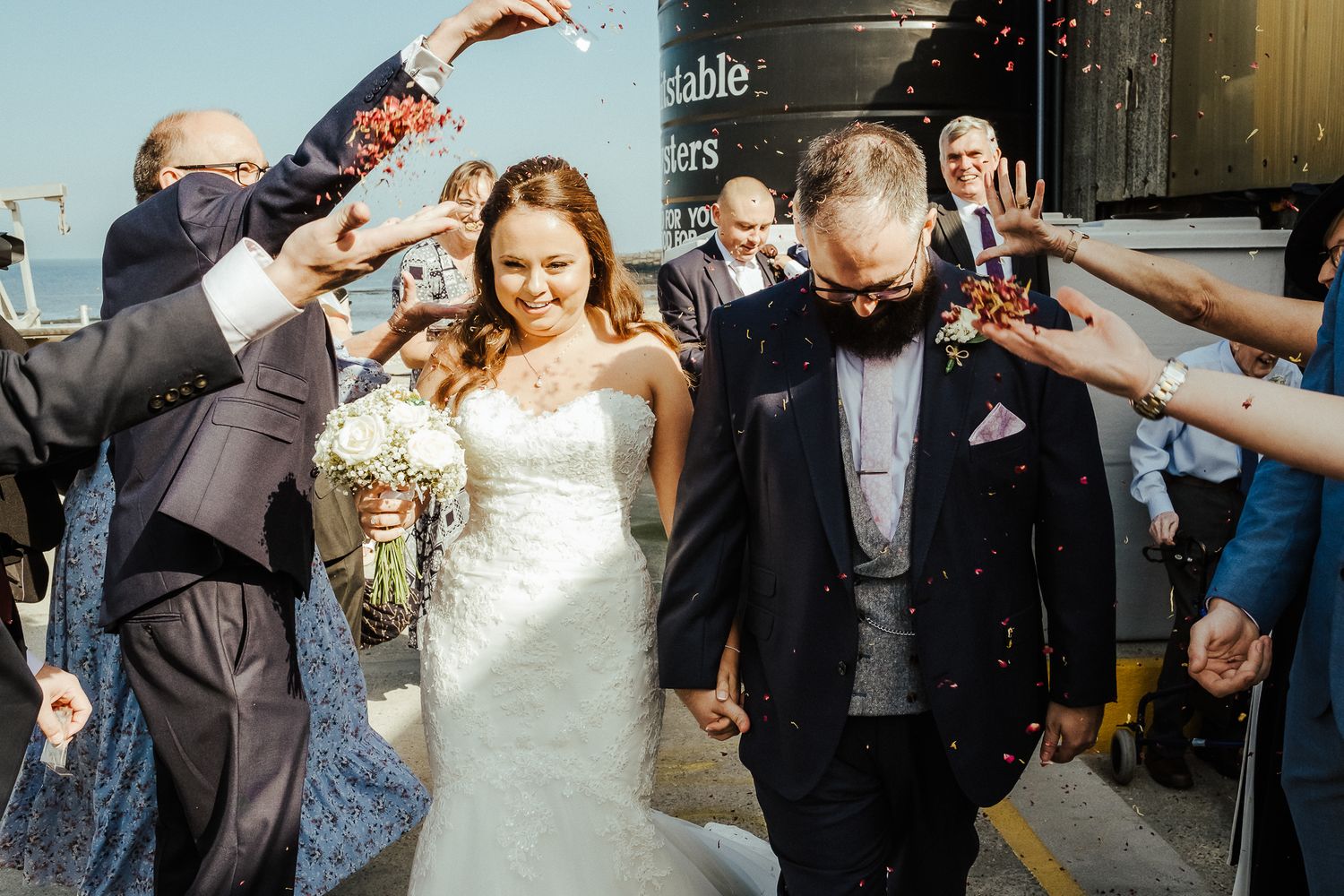Wedding party celebration with guests toasting and celebrating in formal attire.