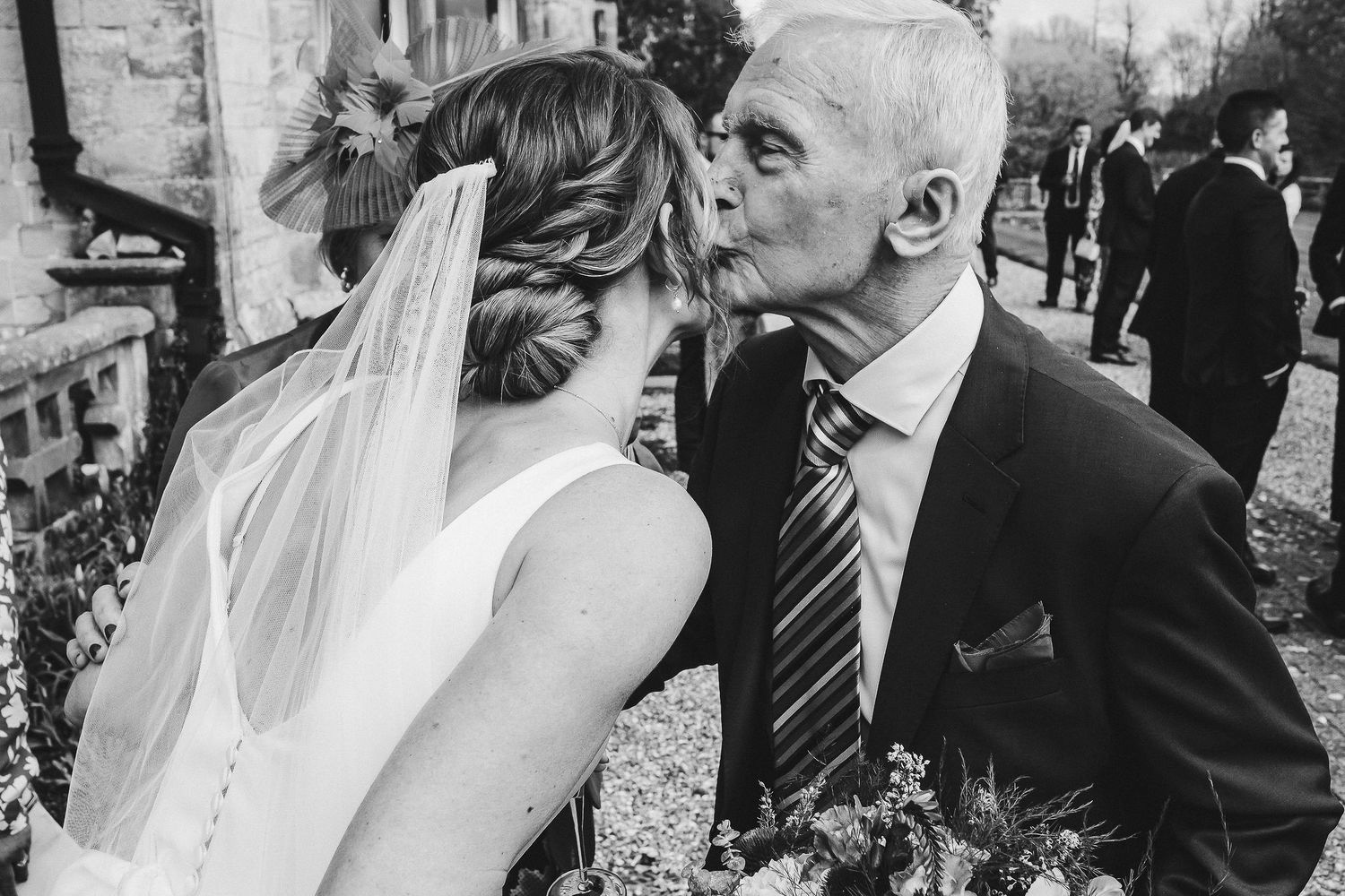 Black and white candid moment between bride and loved one outside.