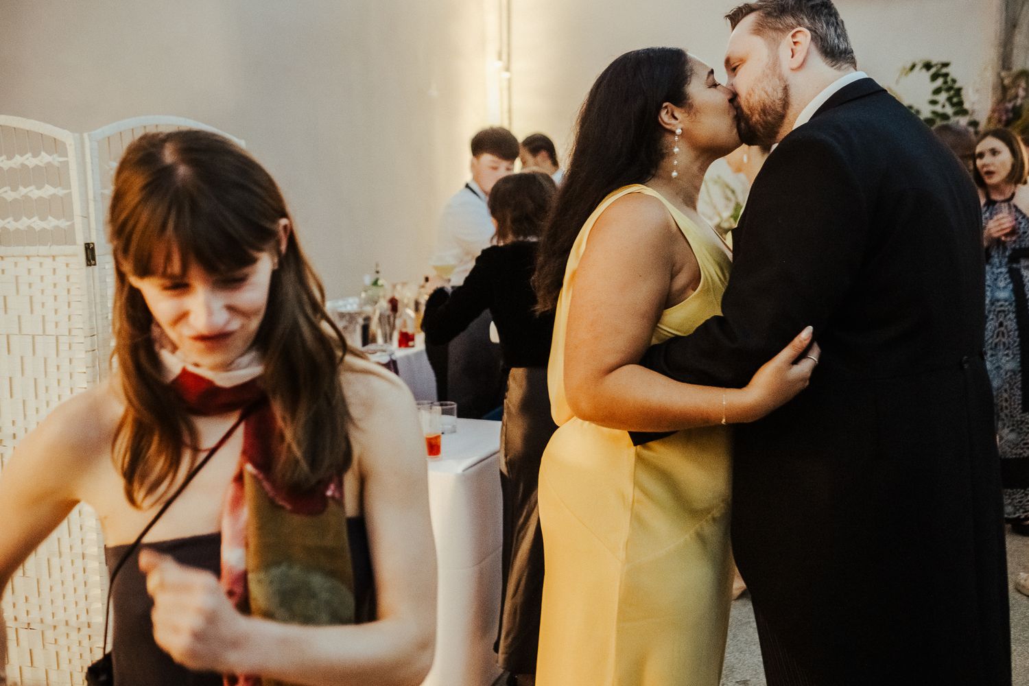 Intimate moment between couples at an indoor celebration with warm lighting.