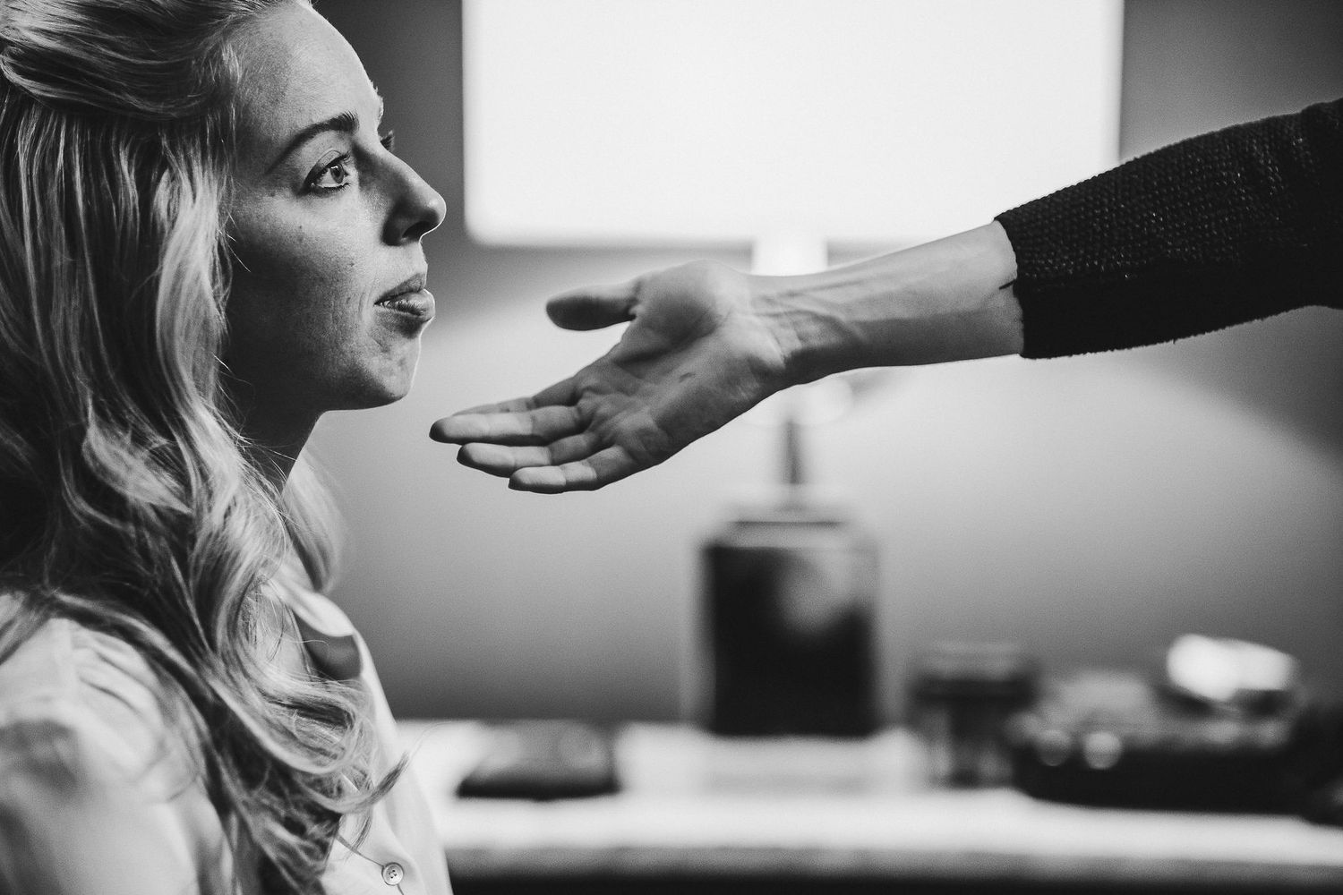 Black and white image showing a hand reaching out in a candid moment.