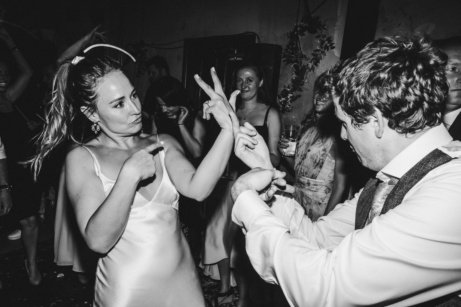 Dance party guests enjoying themselves in a dimly lit venue with dramatic lighting effects.