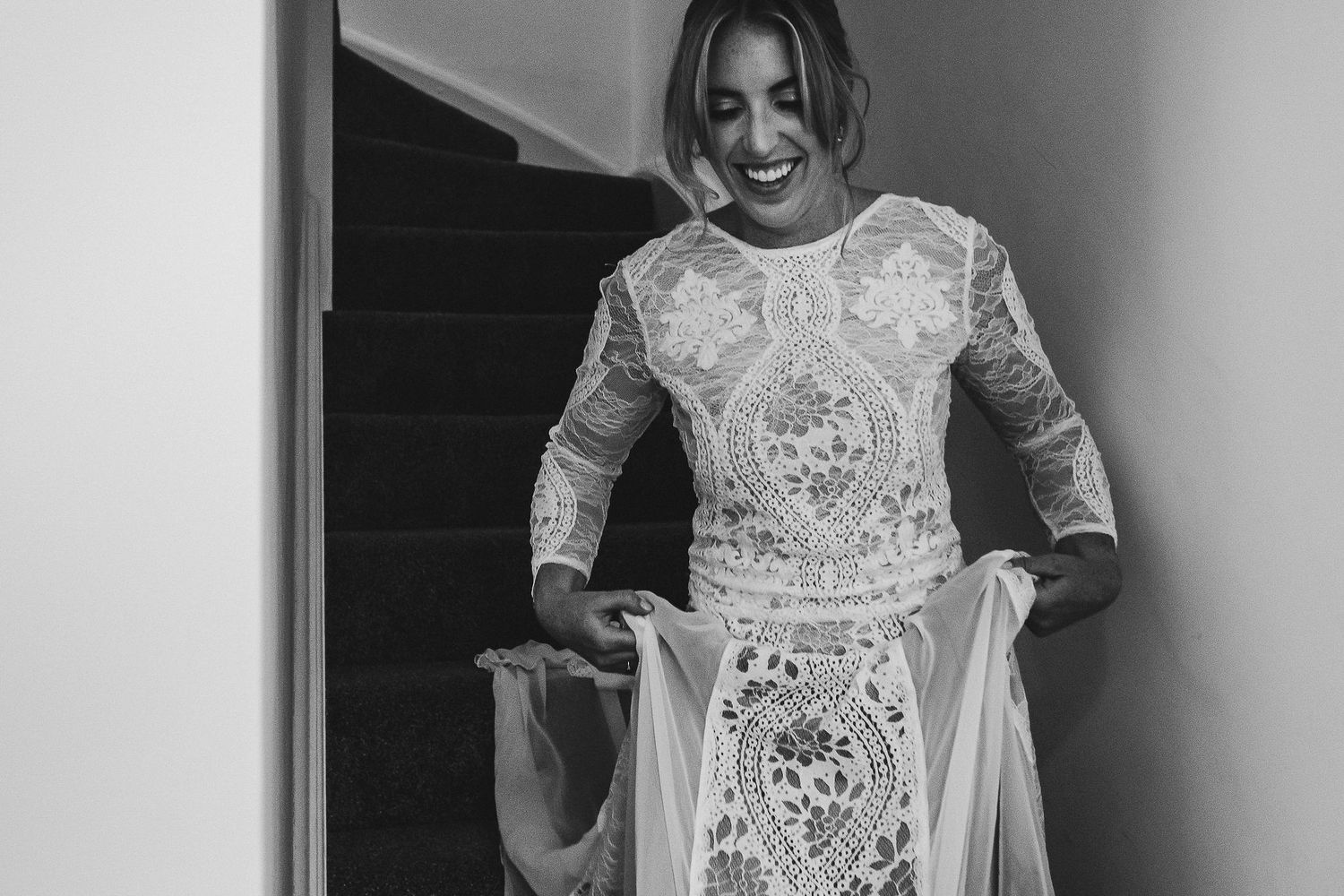 Candid moments of wedding preparation showing detailed lace dress and natural lighting.