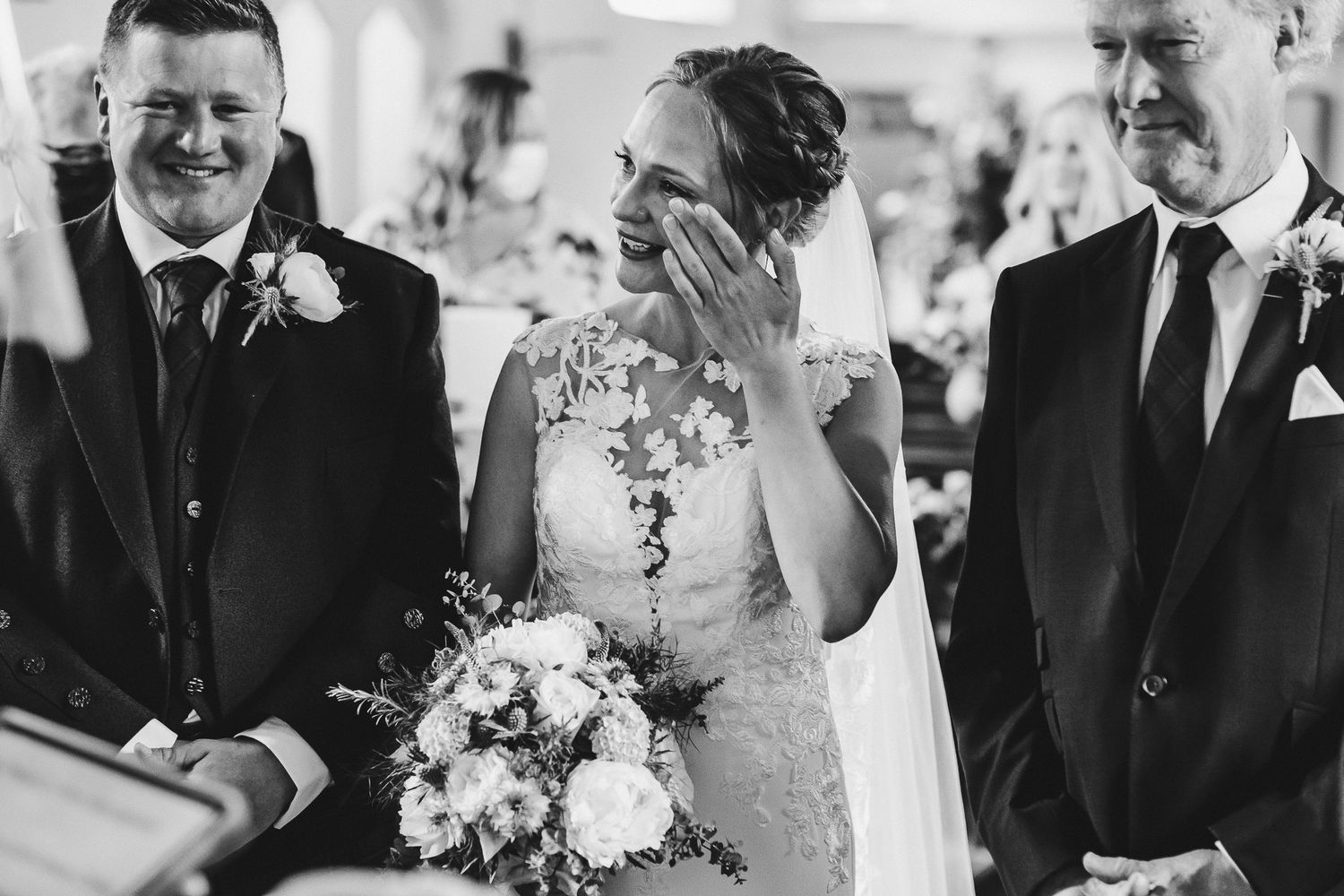 Emotional wedding ceremony moment captured in black and white.