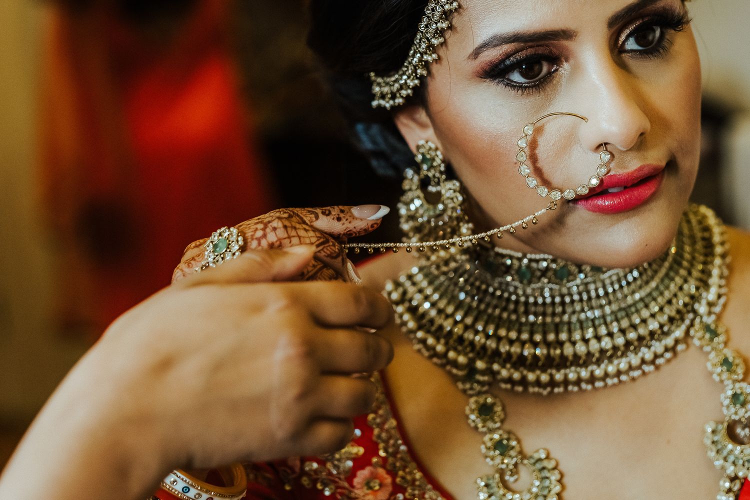 Close-up of traditional Indian bridal jewelry and ornate nose ring detail.