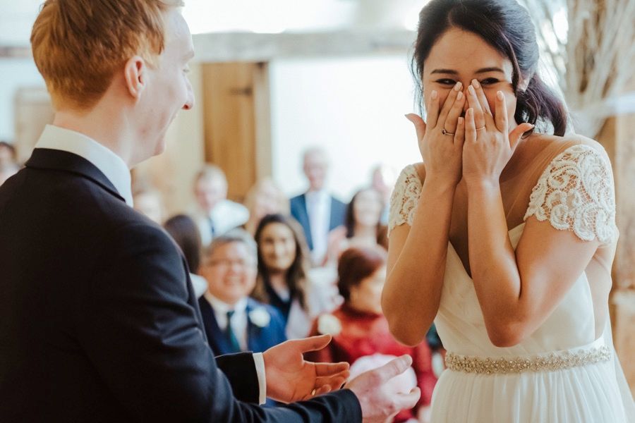 Emotional wedding ceremony moment as bride reacts to groom's vows.