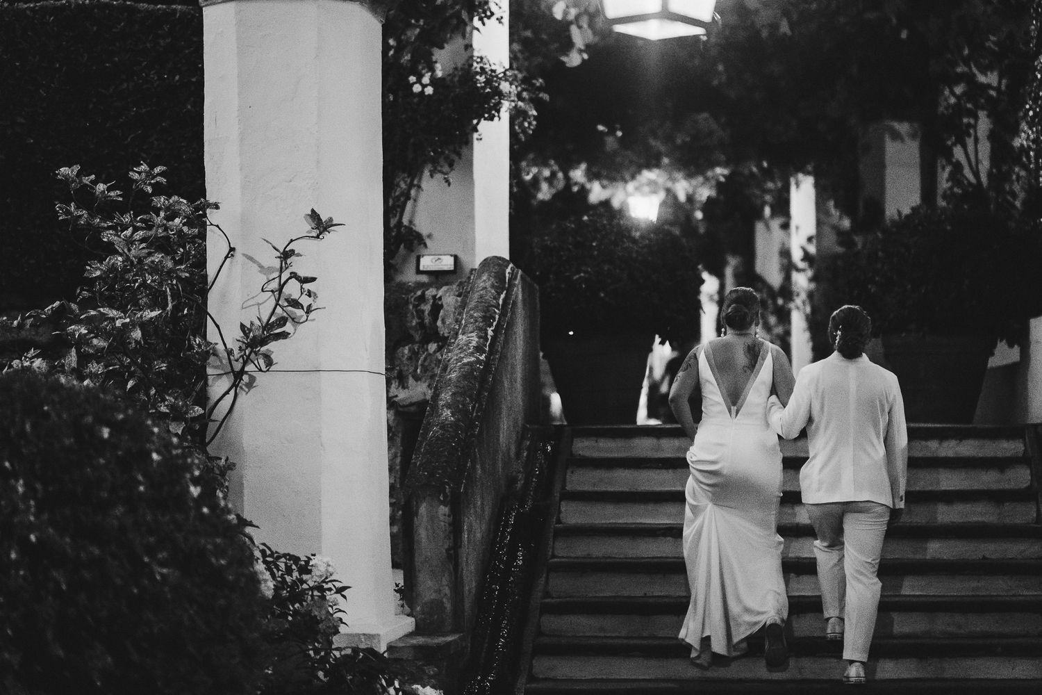 Evening wedding party scene with silhouettes walking under string lights.