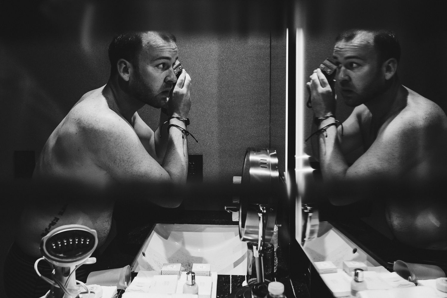 Artistic black and white portrait of a reflection in a bathroom mirror.