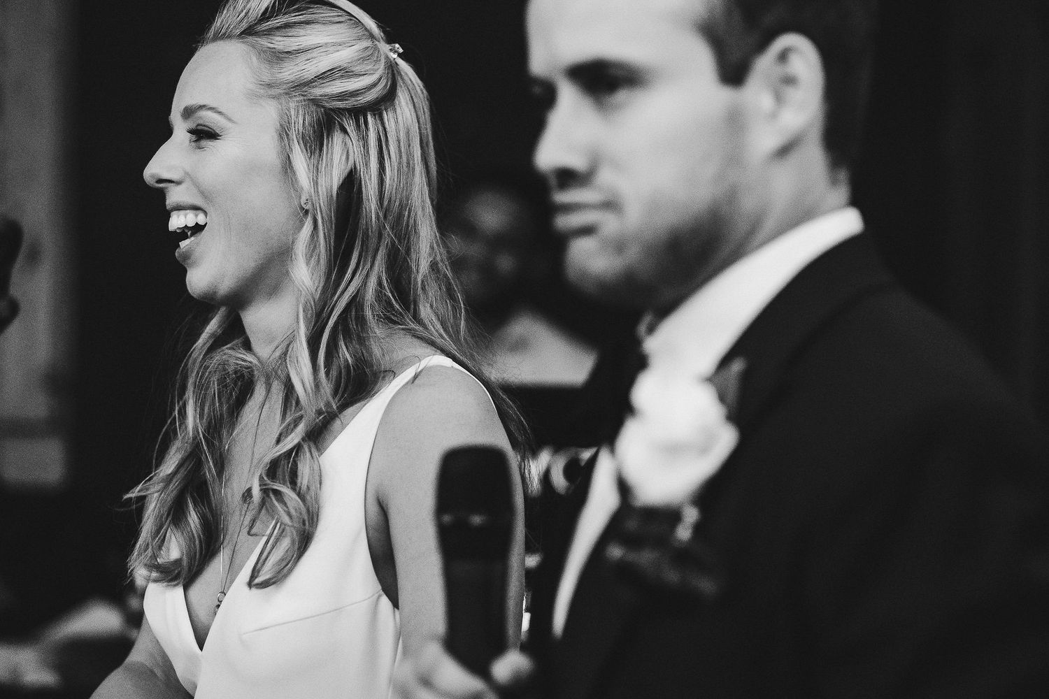 Black and white candid photo captures joyful moment at formal celebration.