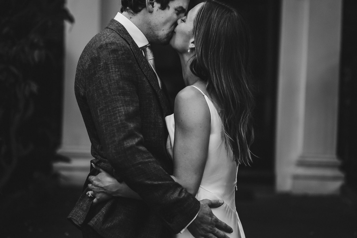 Black and white romantic moment captured at an elegant indoor venue.