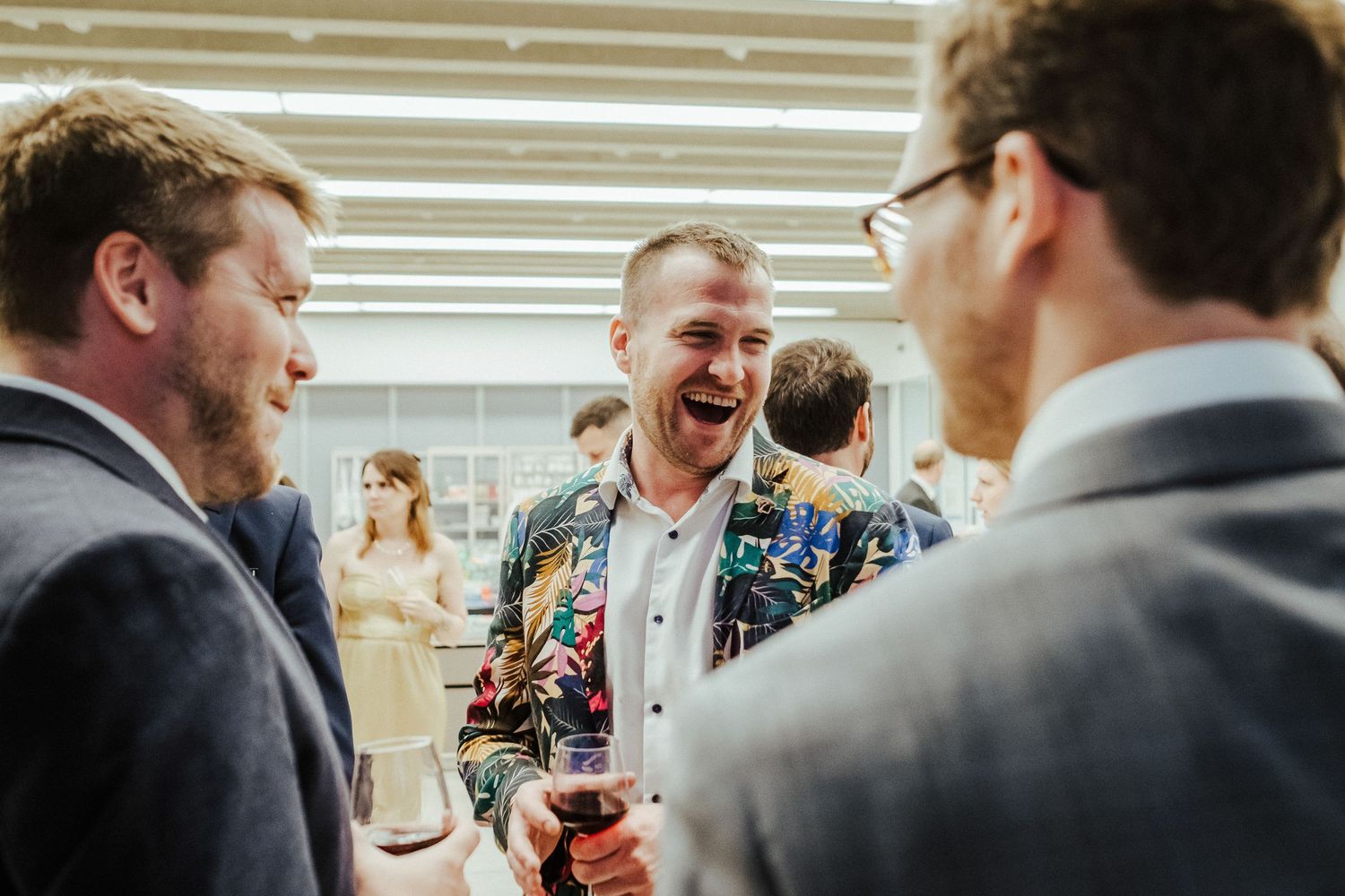 Joyful candid moments shared between wedding guests during an indoor celebration.