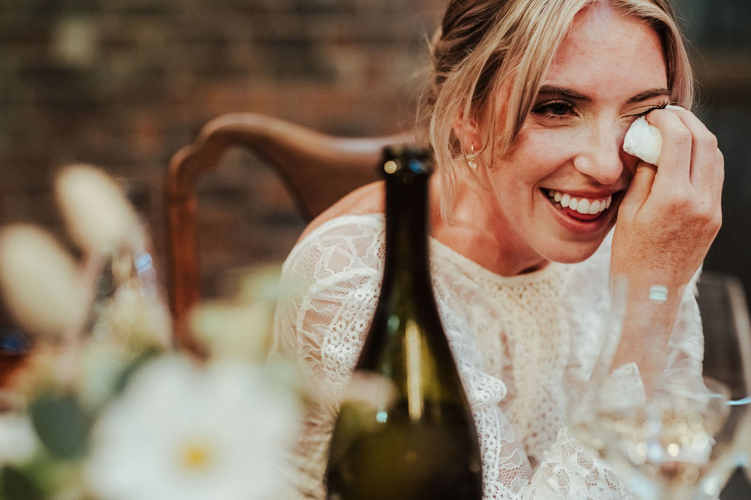 An intimate moment captured during a wedding reception with vintage decor and warm lighting.