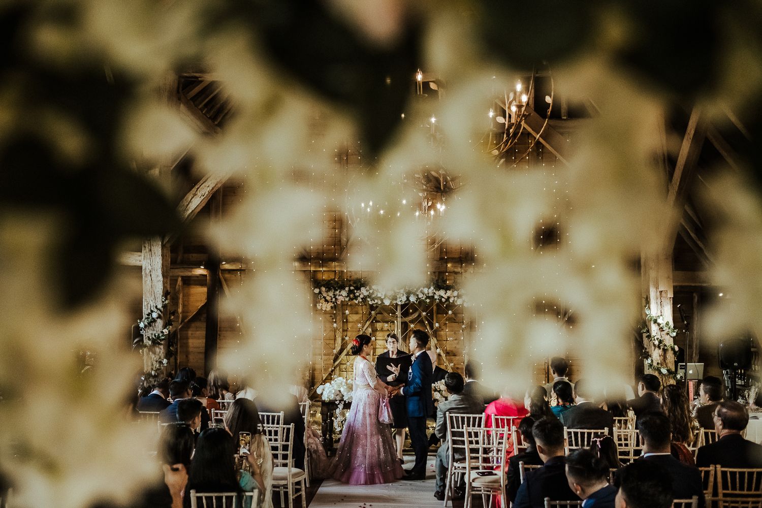 Silhouetted wedding guests celebrating under twinkling reception lights.