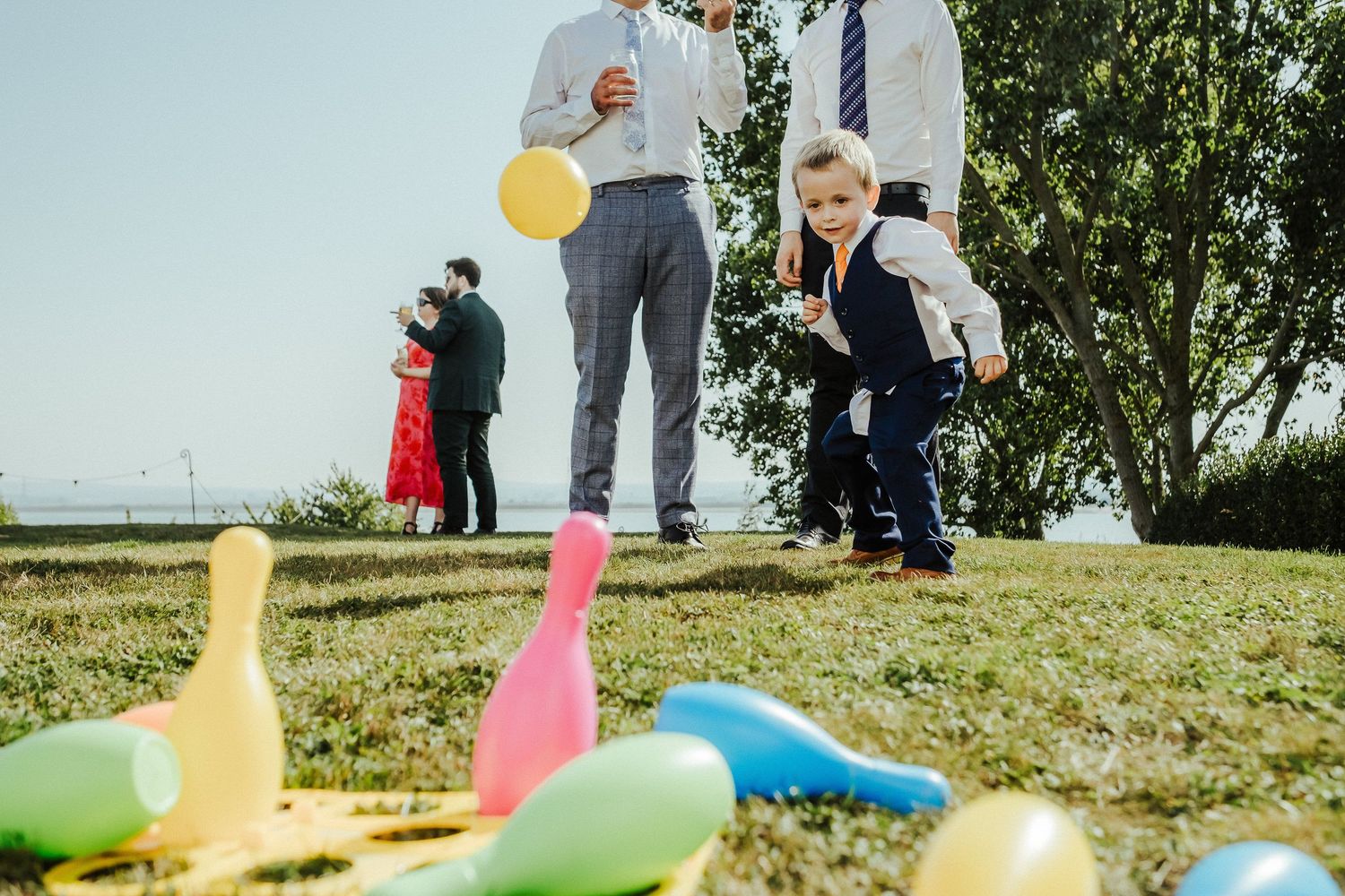 Children play lawn games with colorful pins and balls during an outdoor celebration.