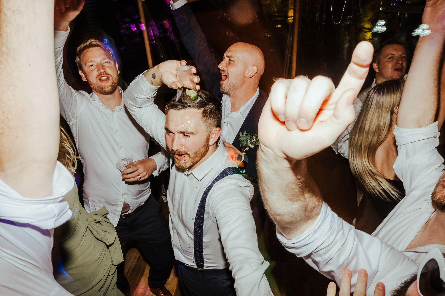 Energetic dance floor scenes from a lively wedding reception party.