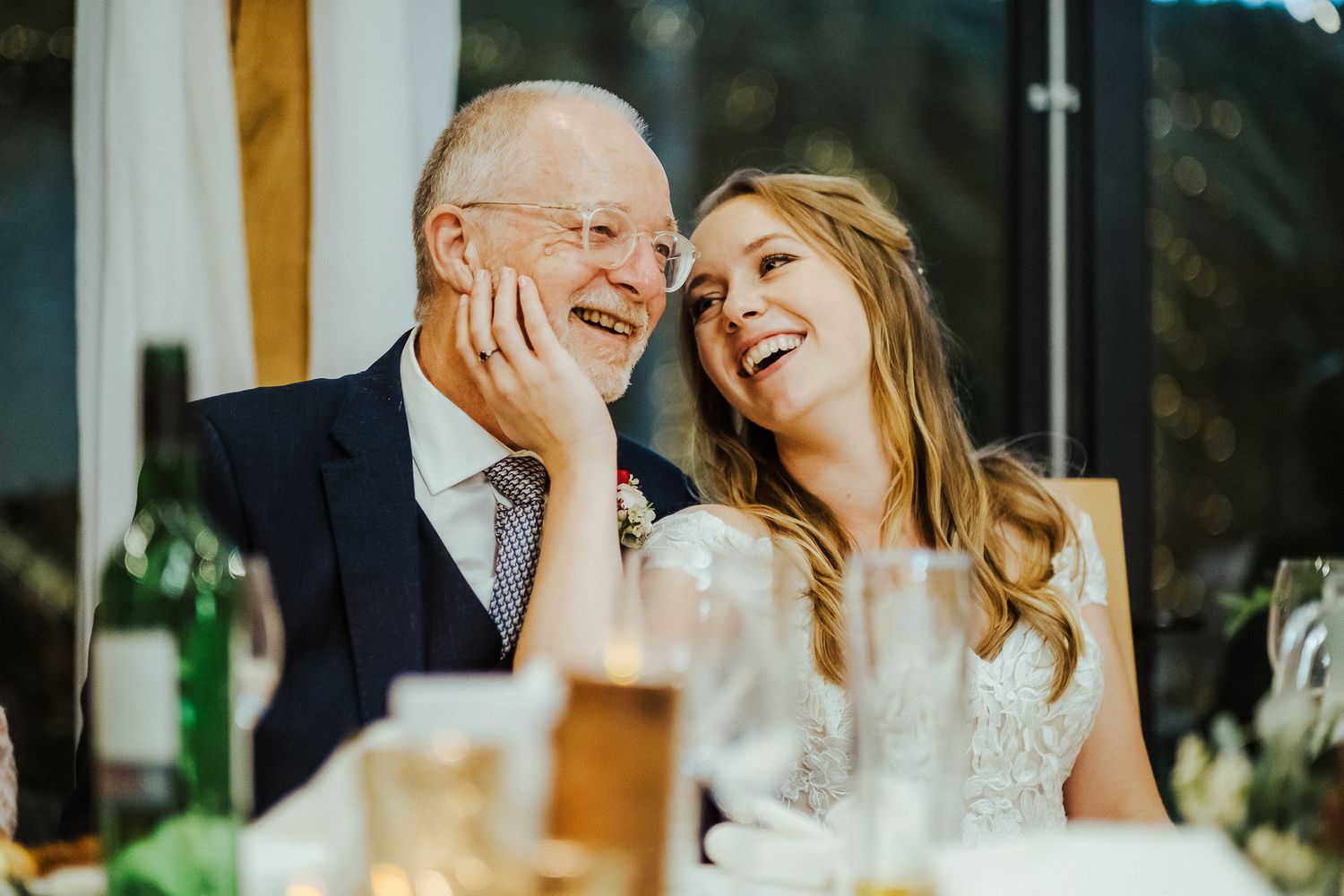Joyful wedding reception candid moments during dinner speeches.