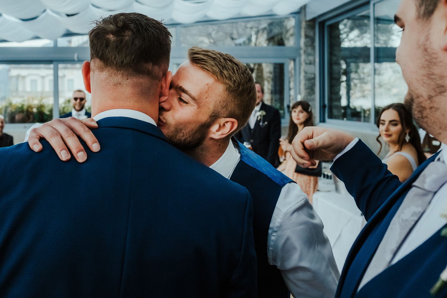 Emotional embrace between guests at an elegant wedding celebration.
