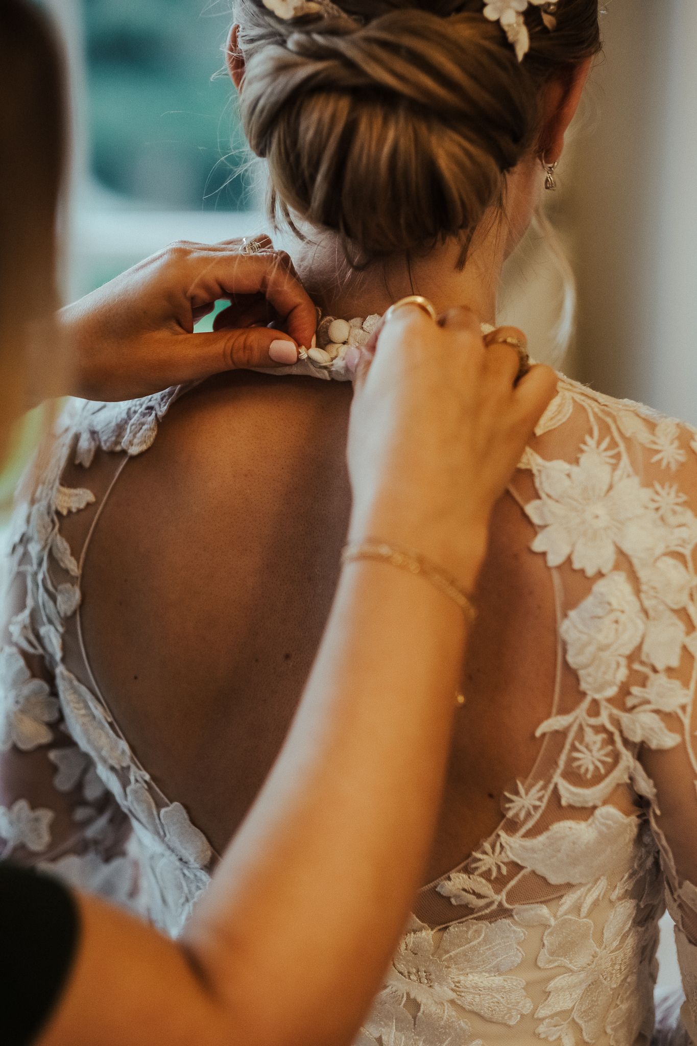 Close-up details of delicate lace and floral appliques on a wedding dress back.