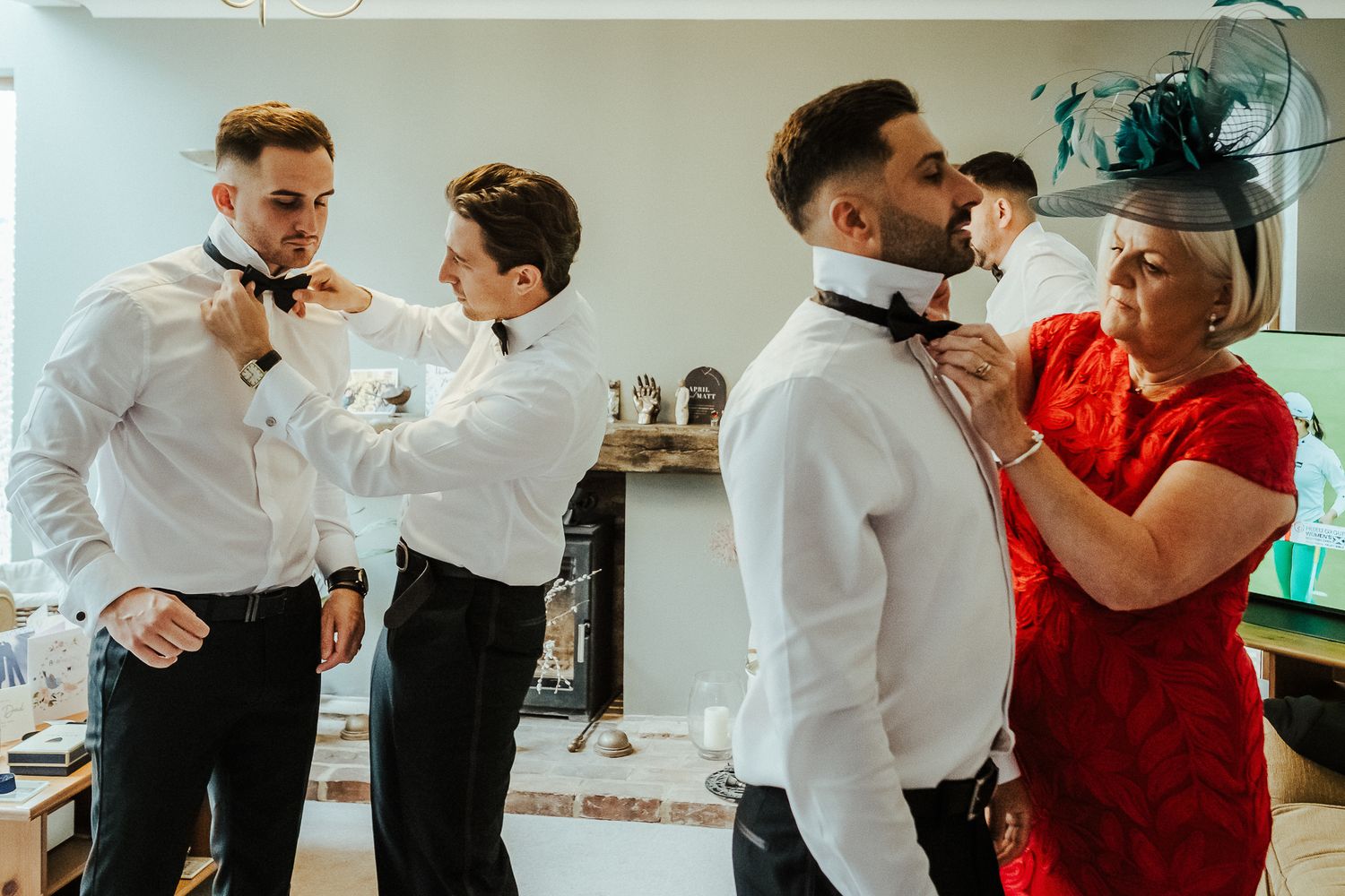 Candid wedding preparation scene showing final touches being made to formal attire.