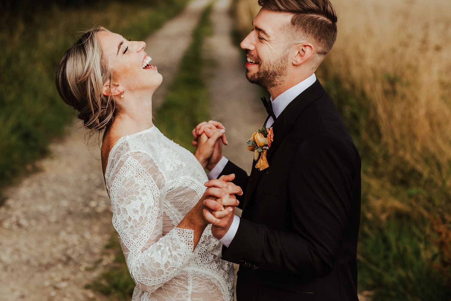Happy couple sharing a joyful moment together on their wedding day on a countryside path.